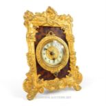 A 19th century French ormolu and tortiseshell easel desk clock, the ivorine dial with painted with