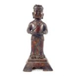 A Chinese bronzed model of a standing male Buddha with out-swept arms and raised on a pierced square