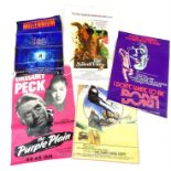 A collection of unframed vintage film posters including 'The Purple Plain' starring Gregory Peck