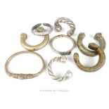 Seven Bedouin white metal bracelets of different sizes; each with plain carved decorations.