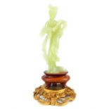 A late 19th / early 20th century carved translucent green jade standing figure Guanyin on a fitted