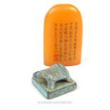 Two Chinese seals consisting of one domed orange soapstone example adorned with character marks on