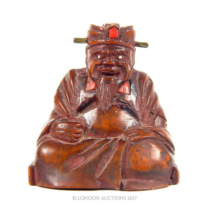 A 19th century wooden figure of a seated sage
