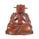 A 19th century wooden figure of a seated sage