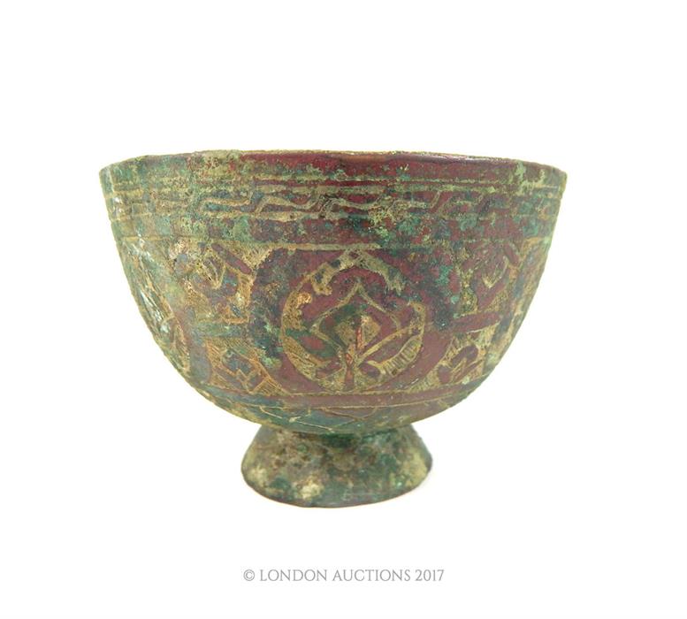 An Islamic bronze bowl with floral engraving amd also featuring a Persian signature to its base; 9.7