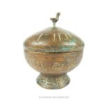 An islamic white metal lidded bowl engraved with inscriptions; 17 cm high.