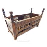 An 18th century oak crib with turned spindles to the sides