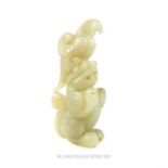 A Chinese carved jade bird figure resting upon a carved leaf