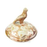 A Kashan ceramic lid decorated with a bird upon its top; 11 cm diameter.