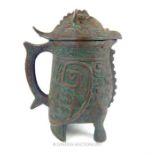A bronzed, white metal lidded jug in the ancient South American style