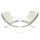 A pair of leather and polished steel Barcelona chairs after a design by Ludwig Mies van der Rohe,