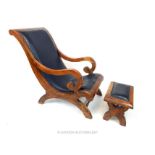 A teak and dark brown leather lounging chair and stool