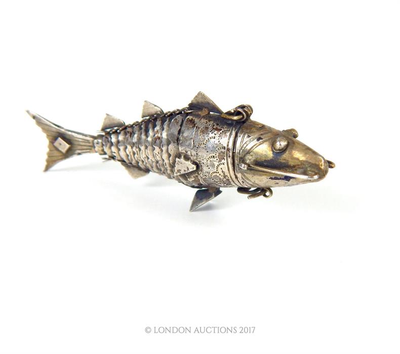 A small 19th century silver Indian pefume bottle in the form of articulated fish, 8cm long