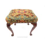 A Victorian walnut stool, upholstered in needlepoint