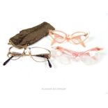 Two pairs of vintage 1950s cats eye spectacles with pink celluloid frames and another folding pair f