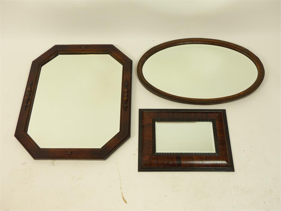 A collection of three mirrors including a rectangular rosewood wall mirror