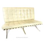 A Barcelona style two seater sofa with buttoned ivory faux leather cushions