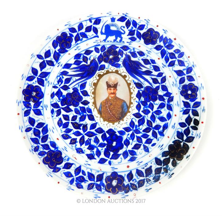 An early 20th century Persian blue and white plate, featuring Nazerldin Shah, with gold