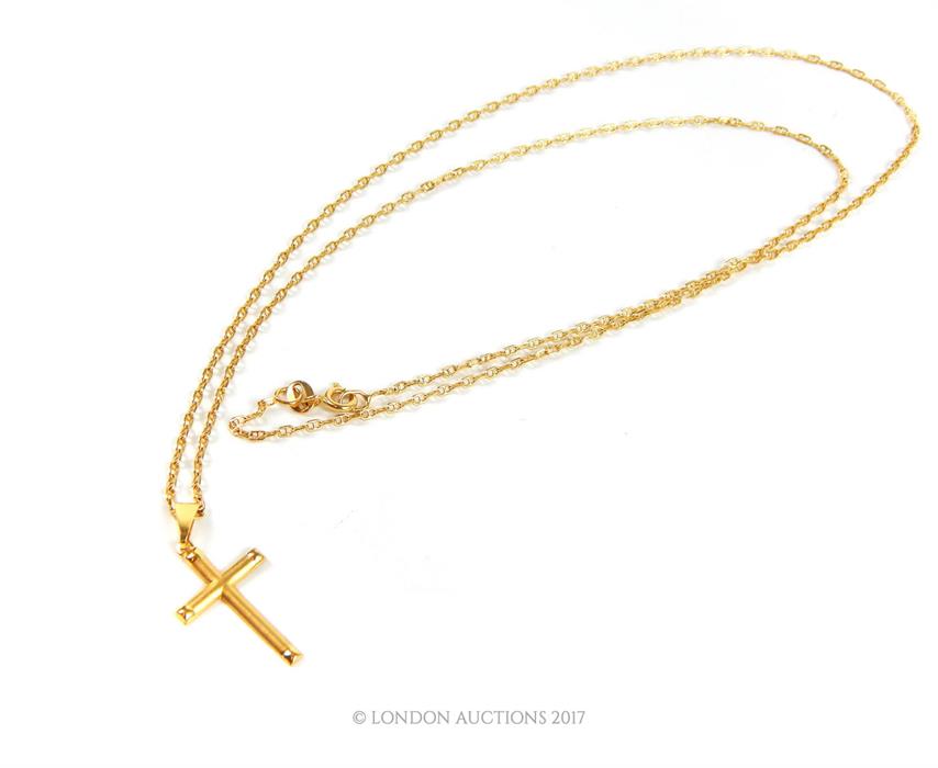 An 18 ct gold chain, marked 750, 60 cm long with an 18 ct gold crucifix pendant 3 cm long. Approx