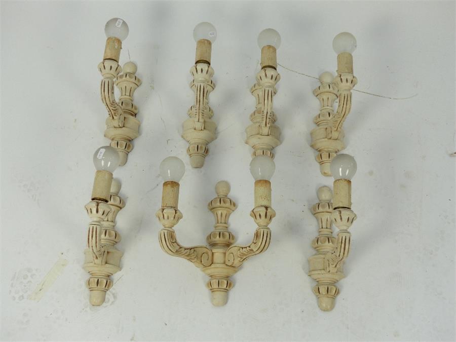 A set of seven painted and distressed carved pine wall lights