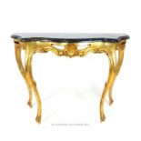 A giltwood console table, having a serpentine marble top, over a carved shell frieze