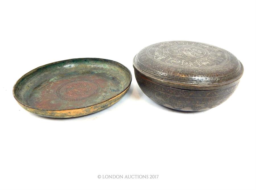 A large, Eastern, hand-beaten, circular copper dish with a stamped star motif decoration to the bowl