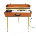 A vintage 1960's Companion Sheltone travel organ / piano, the case covered in brown rexine