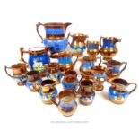 A collection of mid 19th century copper lustre pottery jugs of varying size, most decorated with a