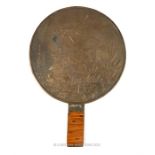 A Japanese circular bronze hand mirror, one side decorated with cranes near a body of water