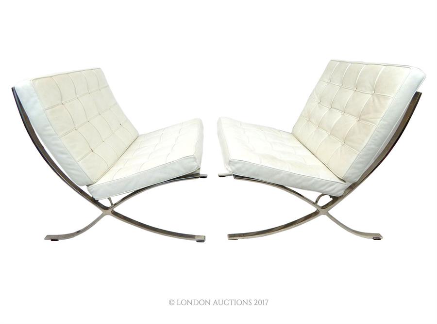 A pair of leather and polished steel Barcelona chairs after a design by Ludwig Mies van der Rohe,
