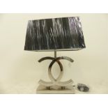 A Chanel style polished steel table lamp with shade