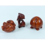 A group of three carved wooden netsuke