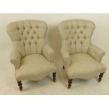 A pair of Victorian style button back armchairs, with serpentine seat and scroll arms, raised on