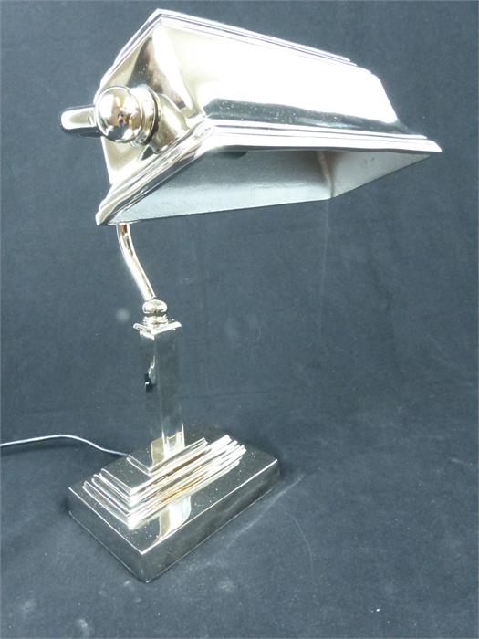 A contemporary chrome bankers desk lamp.