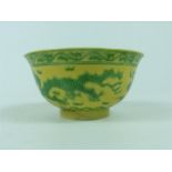 A Chinese porcelain bowl, having an Imperial yellow ground, painted with green dragons