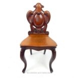 A Victorian mahogany hall chair, with carved scrolling detail to the back