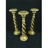 A set of three decorative resin candlesticks with barley twist stems