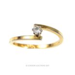 A 9 ct yellow gold, crossover ring with claw-set white stone