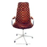 A retro 1970s swivel desk chair with chequered fabric upholstery and chrome frame.