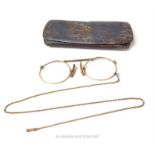 A pair of vintage yellow metal, pince-nez without lenses but with original white metal case.