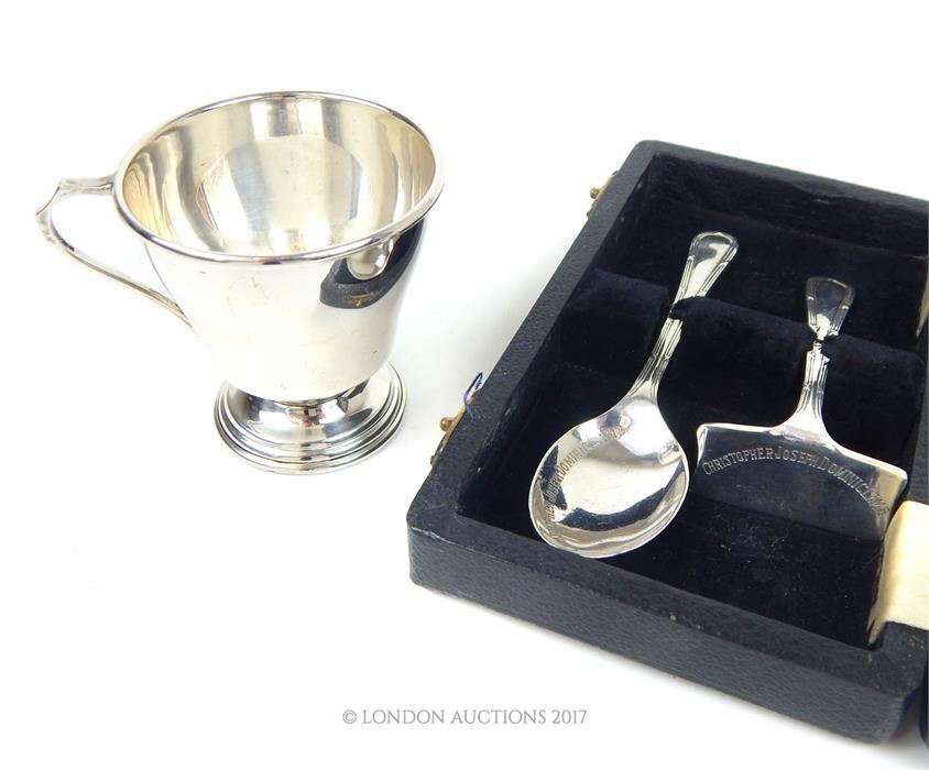 A cased sterling silver child's spoon and pusher with a sterling silver Christening mug