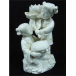 A Chinese blanc de chine figure group, modelled as two young girls, one kneeling holding a basket,