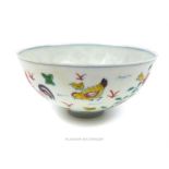 A Chinese porcelain bowl decorated in the doucai palette with hand painted chickens