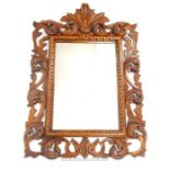 An ornately carved hardwood framed wall mirror; overall height 114cm.