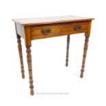 An Edwardian walnut side table with a single drawer raised upon turned legs; 76cm wide.
