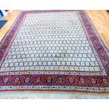 A large signed Persian Senneh carpet, with repeating tile motif, surrounded by seven running borders