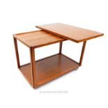 A retro teak trolley table on castors with swivel opening top; 84cm wide