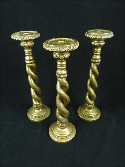 A set of three decorative candlesticks with barley twist stems