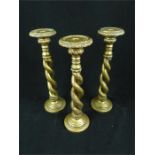 A set of three decorative candlesticks with barley twist stems