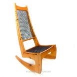 A Jerome K. Brown pine rocking chair with cord mesh seat and back.